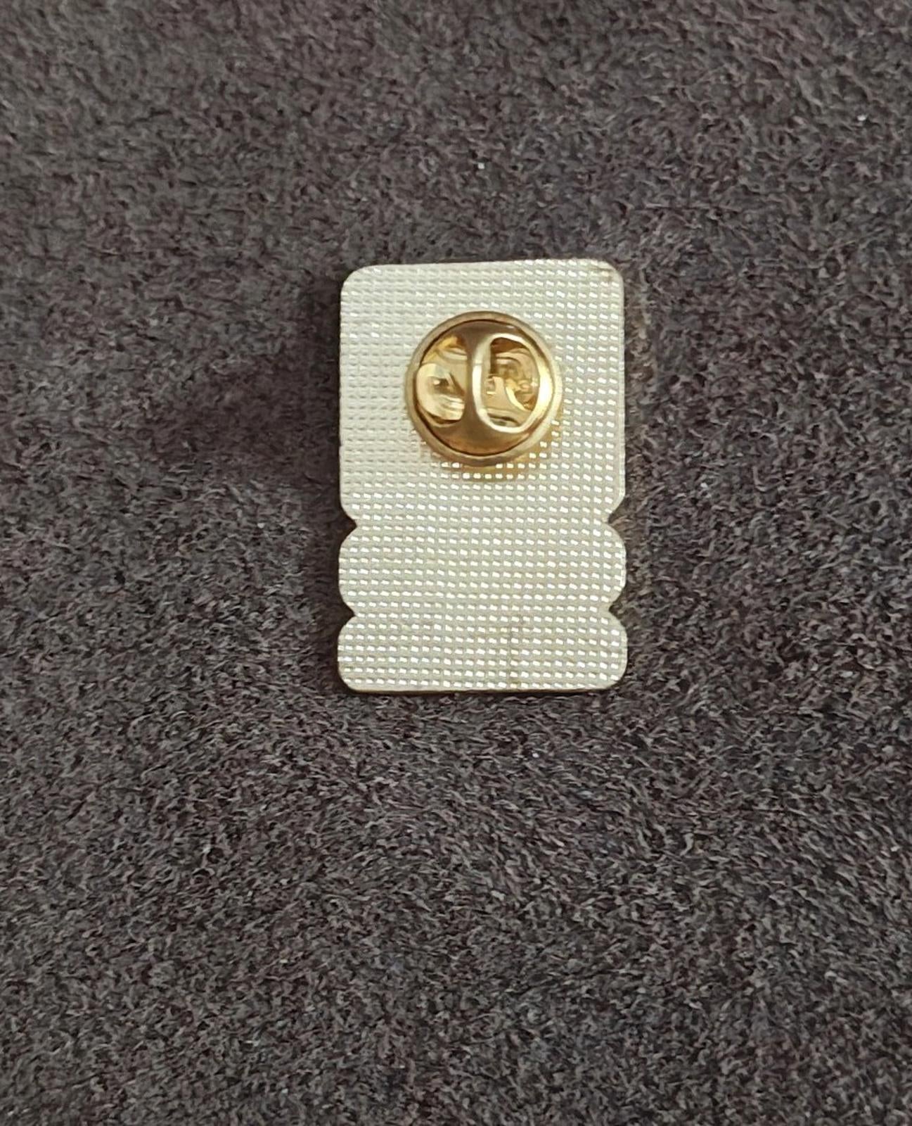 Back of U.S. Army star lapel pin with white backing and gold metal clasp