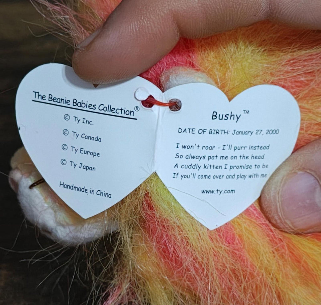 Heart-shaped TY tag on lion plush showing Bushy name and date of birth