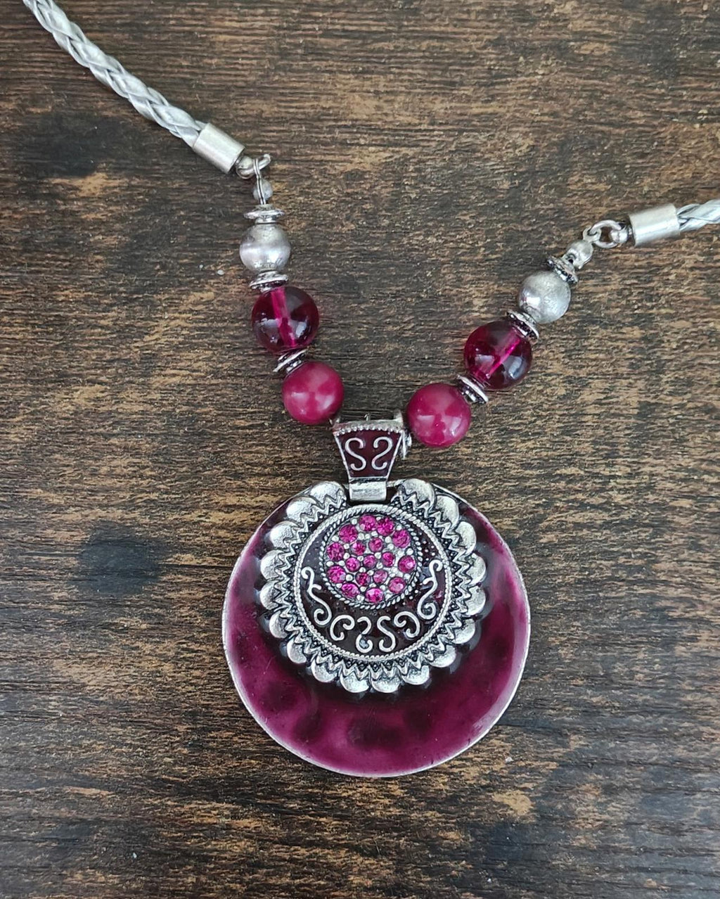 Round burgundy pendant necklace with pink beads and braided silver-tone chain