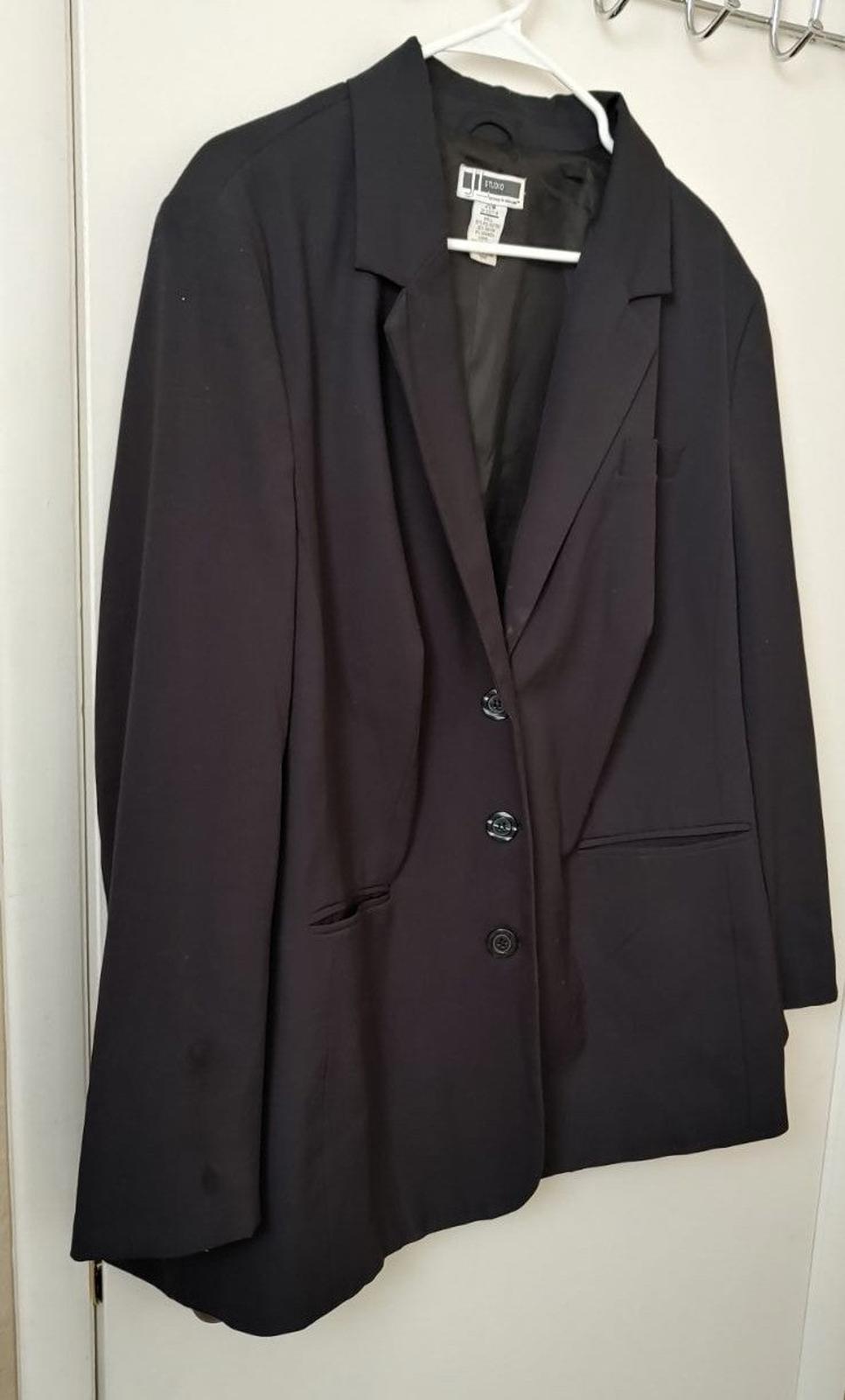 Dark blazer with notched lapels, single-breasted buttons, and flap pockets.
