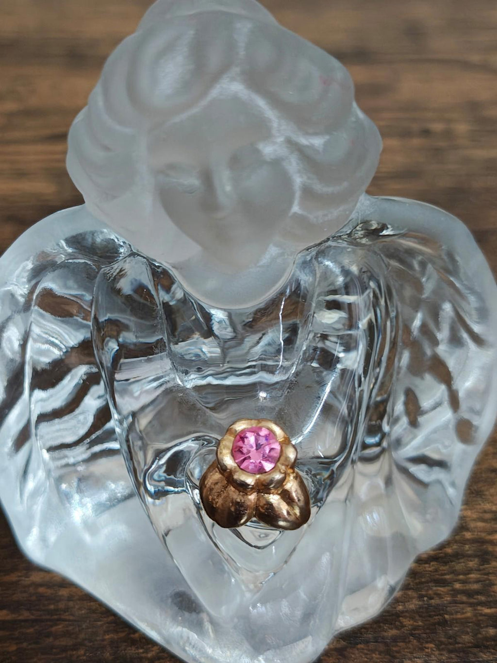 Clear glass guardian angel figurine close-up of pink gemstone heart pendant