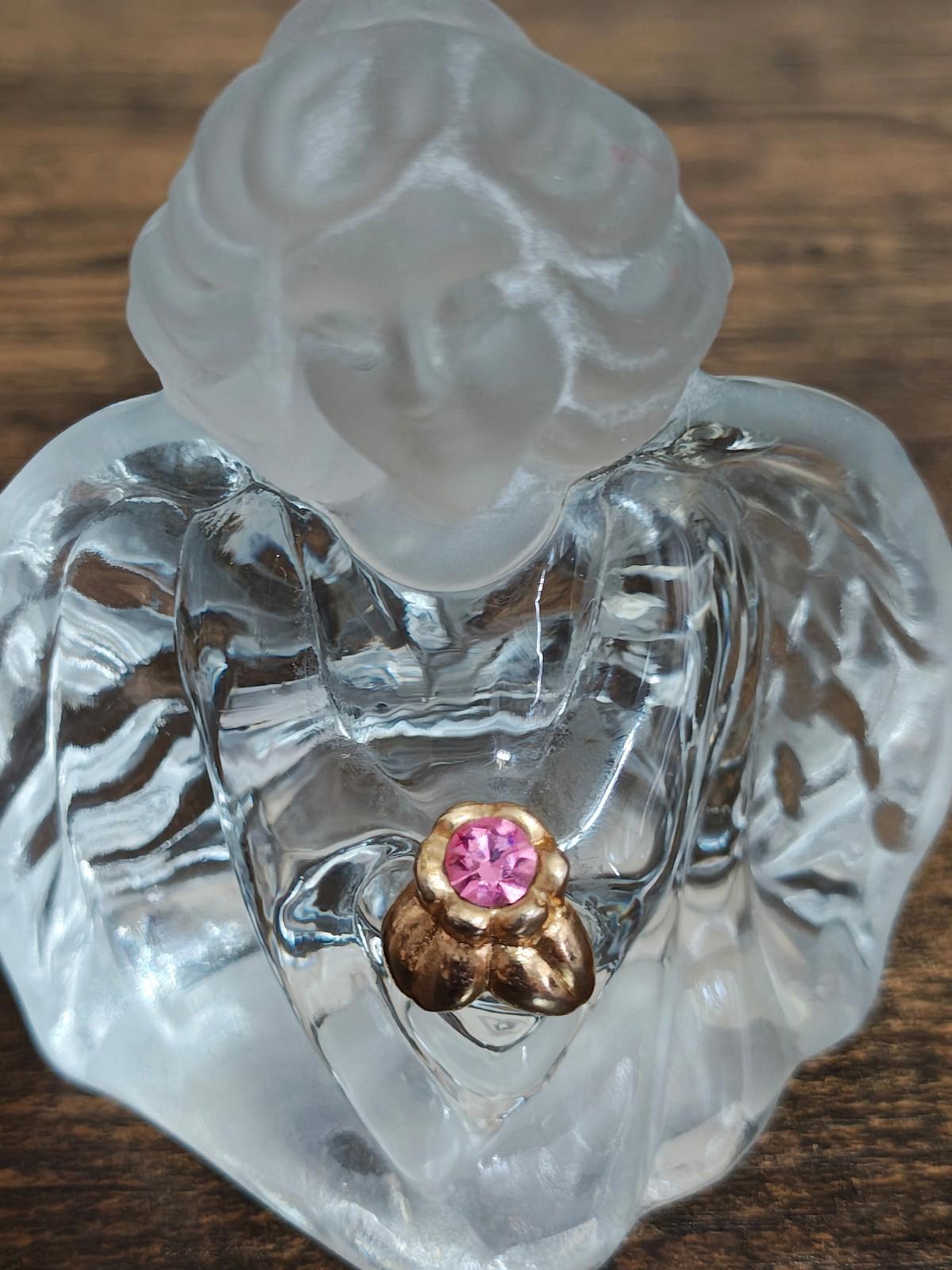 Clear glass guardian angel figurine close-up of pink gemstone heart pendant