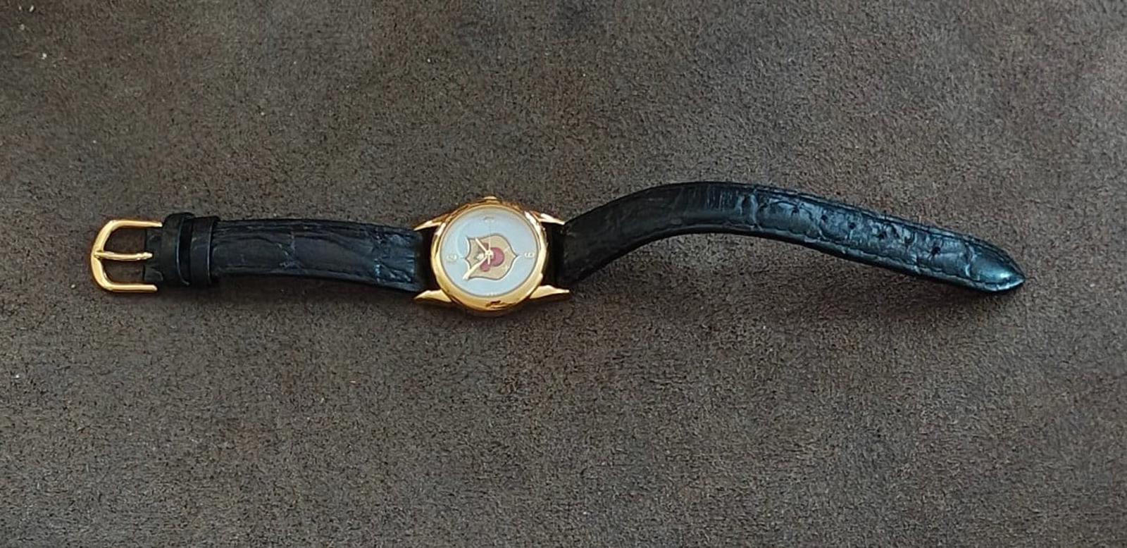 Gold-tone quartz wristwatch with black leather strap, side view with clasp.