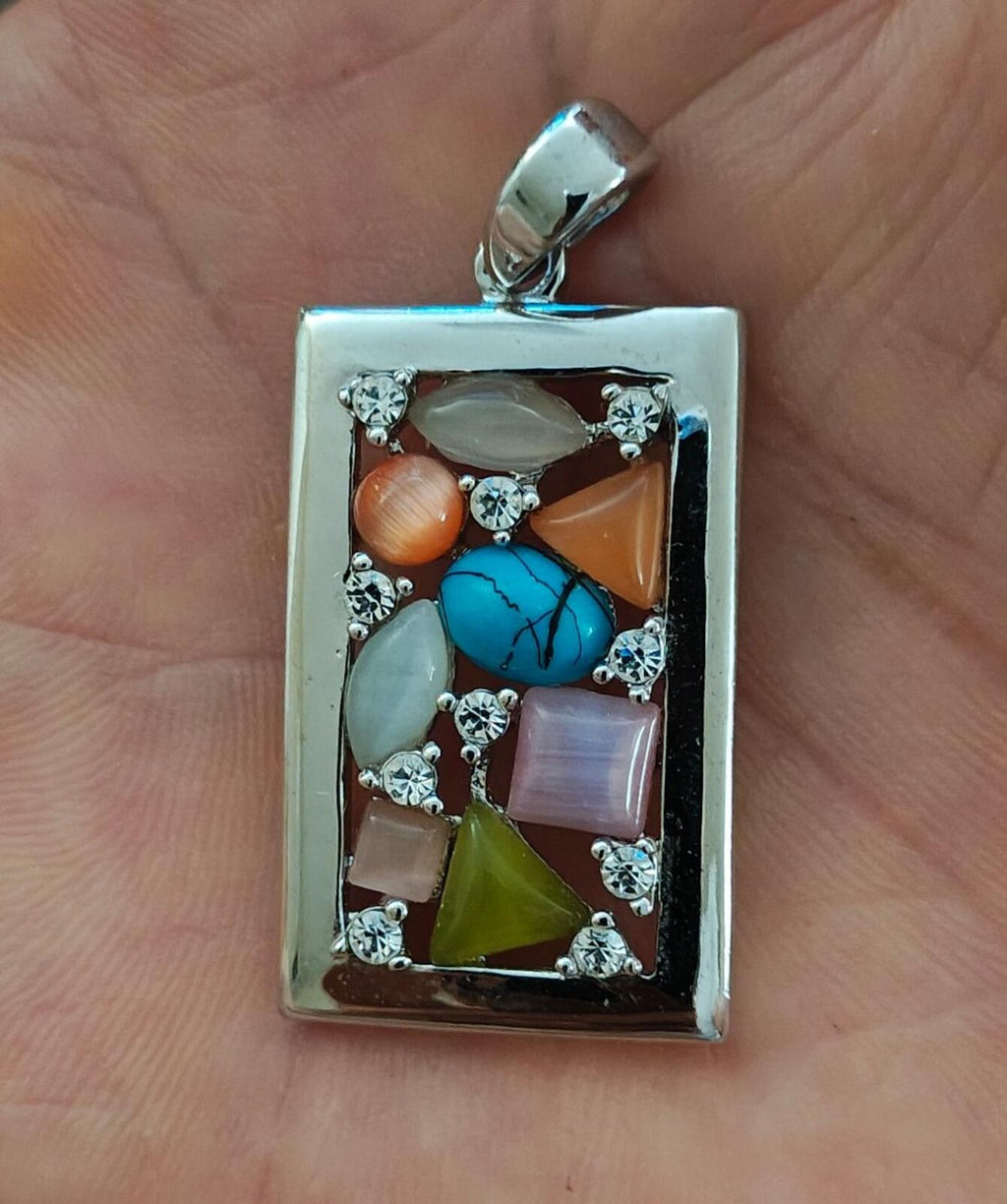 Silver-tone rectangular pendant with turquoise, green, orange and pink stones, jeweled frame