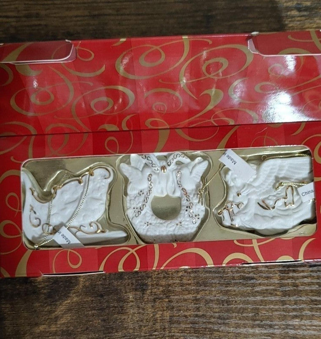 Set of three bisque porcelain ornaments in red box, horse, wreath, and boot designs