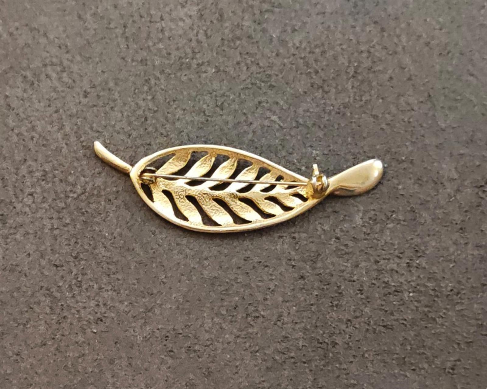 Gold tone leaf brooch with openwork filigree feather motif, pin end visible