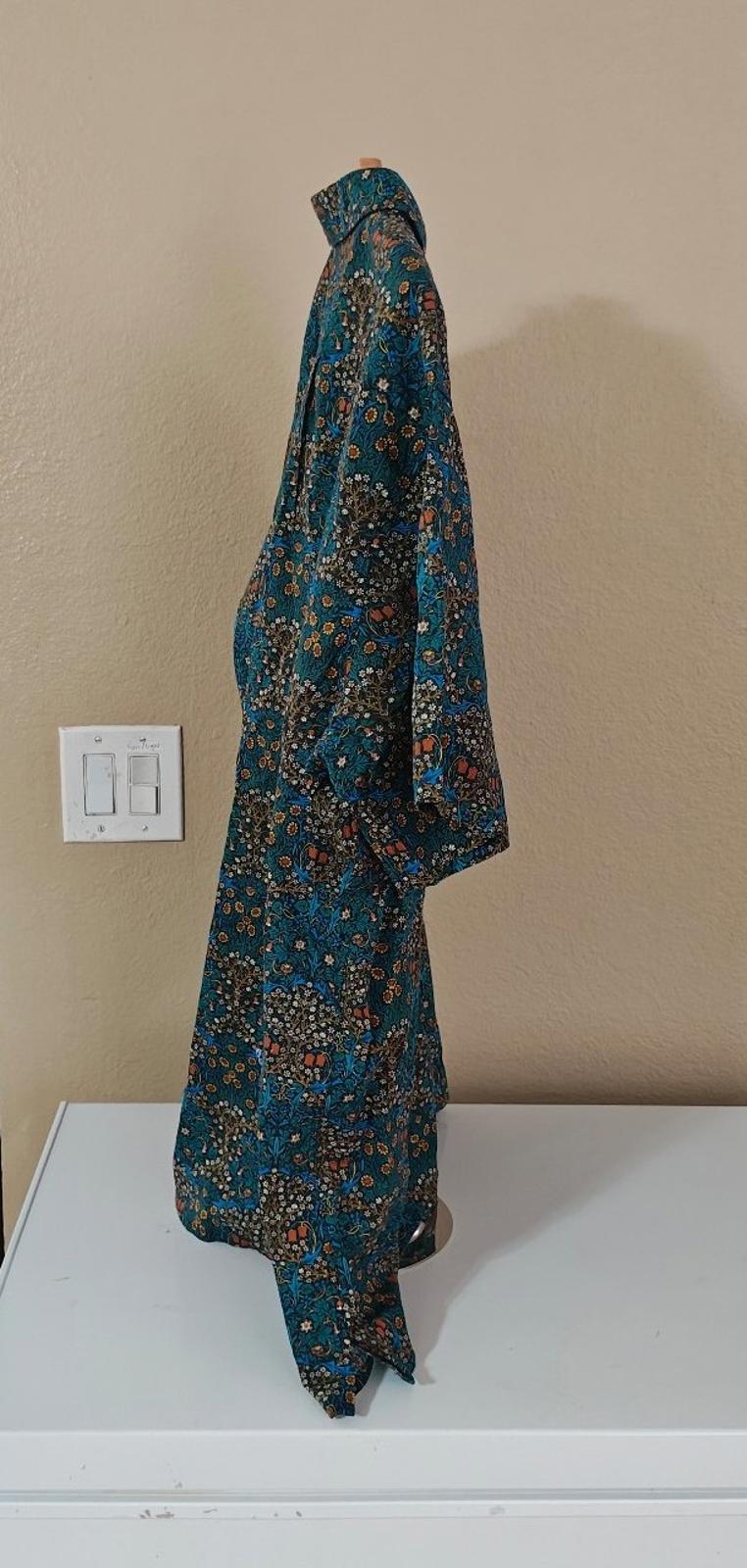 Men's blue floral short-sleeve Hawaiian shirt, angled view with flowing hem and short sleeves