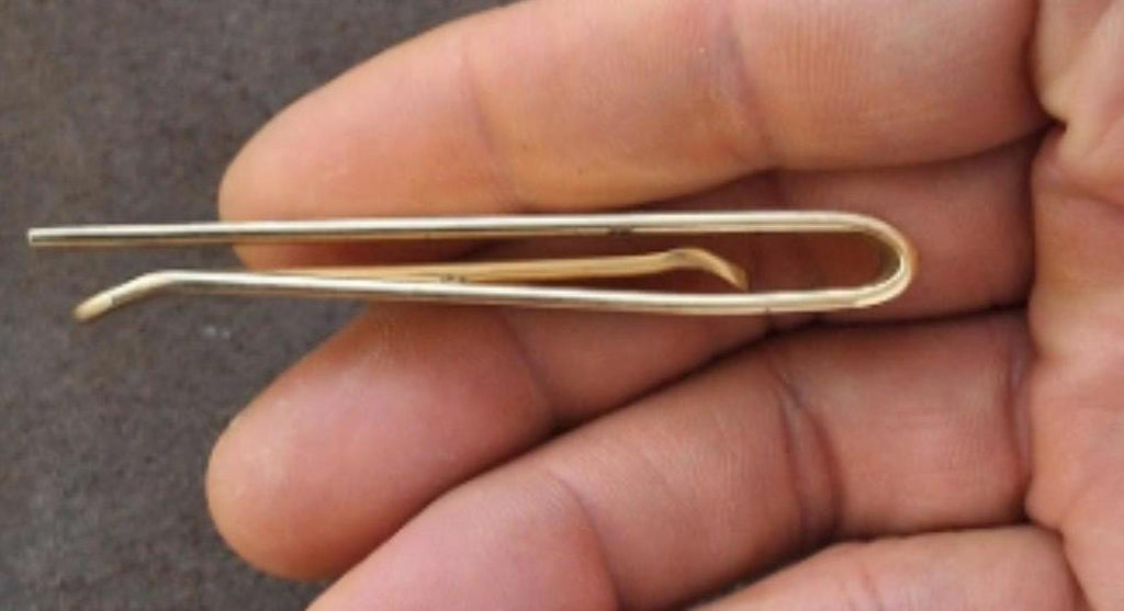 Gold tone tie bar clip showing curved pin and straight bar ends