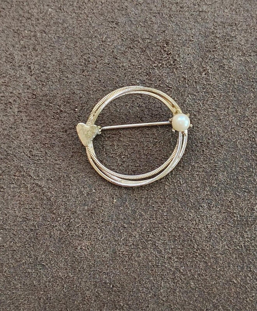 Gold-tone circular eternity brooch with textured band and pearl bead, pin back