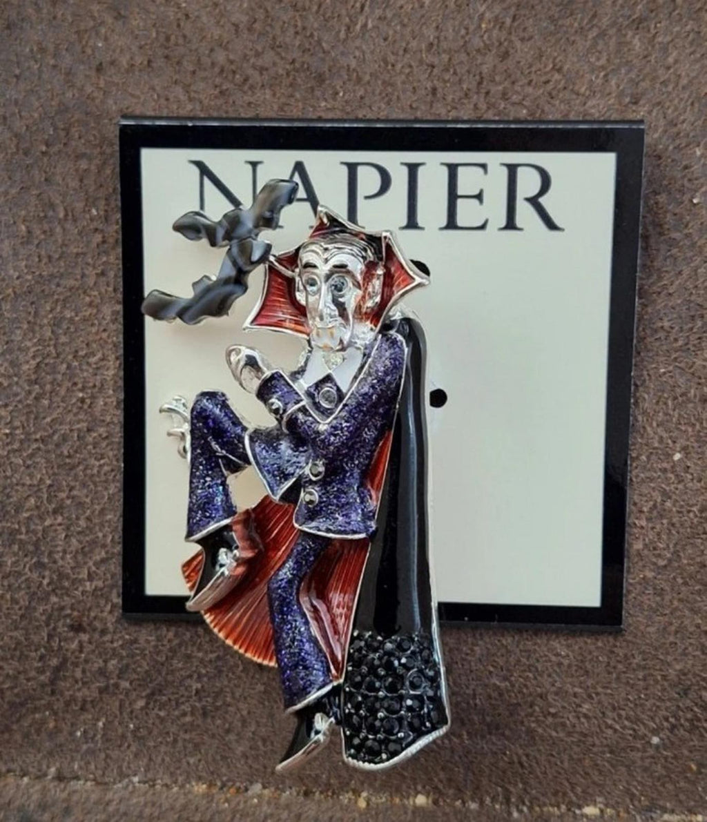 Vampire enamel character pin with raised arms, red cape, and blue glitter detailing