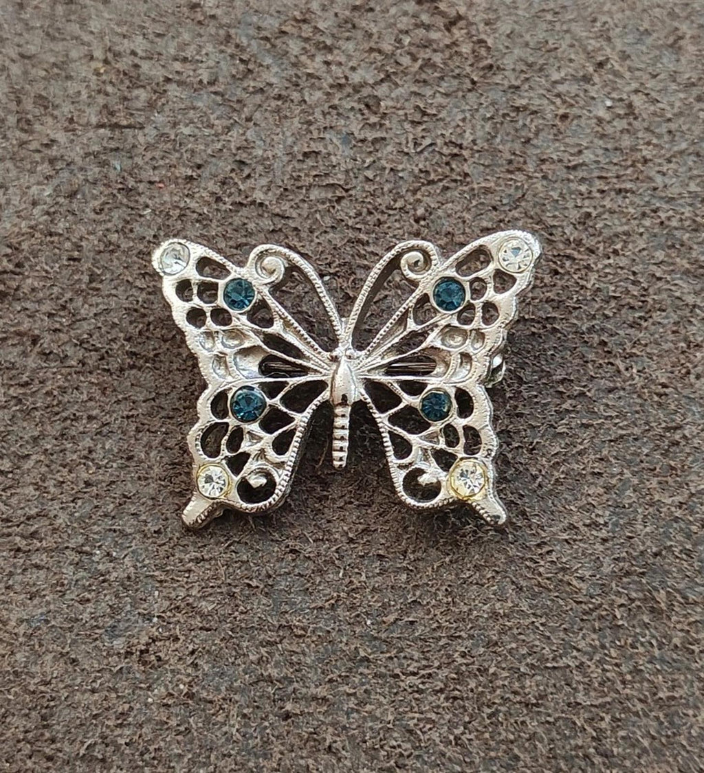 Silver-tone butterfly brooch with clear and blue rhinestones, centered front view