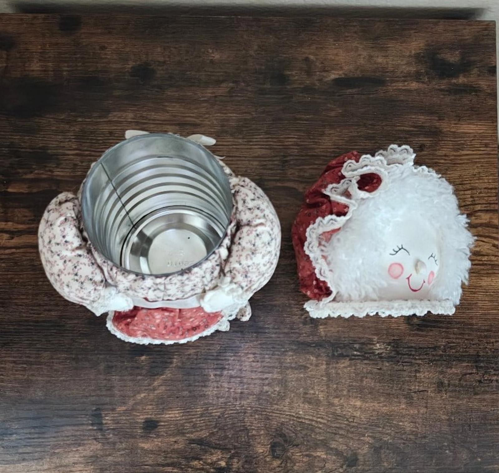 Handmade cloth doll canister set with metal canister, white floral cover, and small doll.