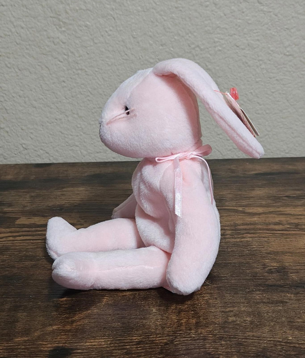 Pink plush bunny beanbag in side pose with folded legs and long ears