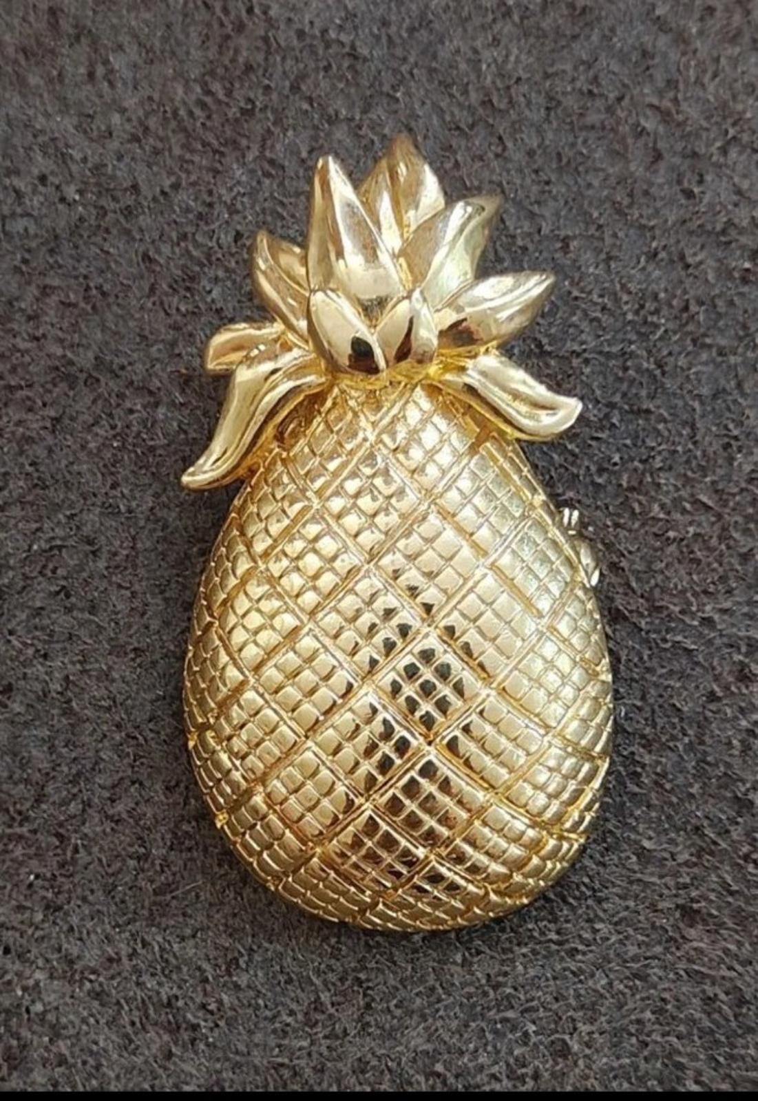 Gold tone pineapple brooch featuring raised leaves and diamond-pattern textured body