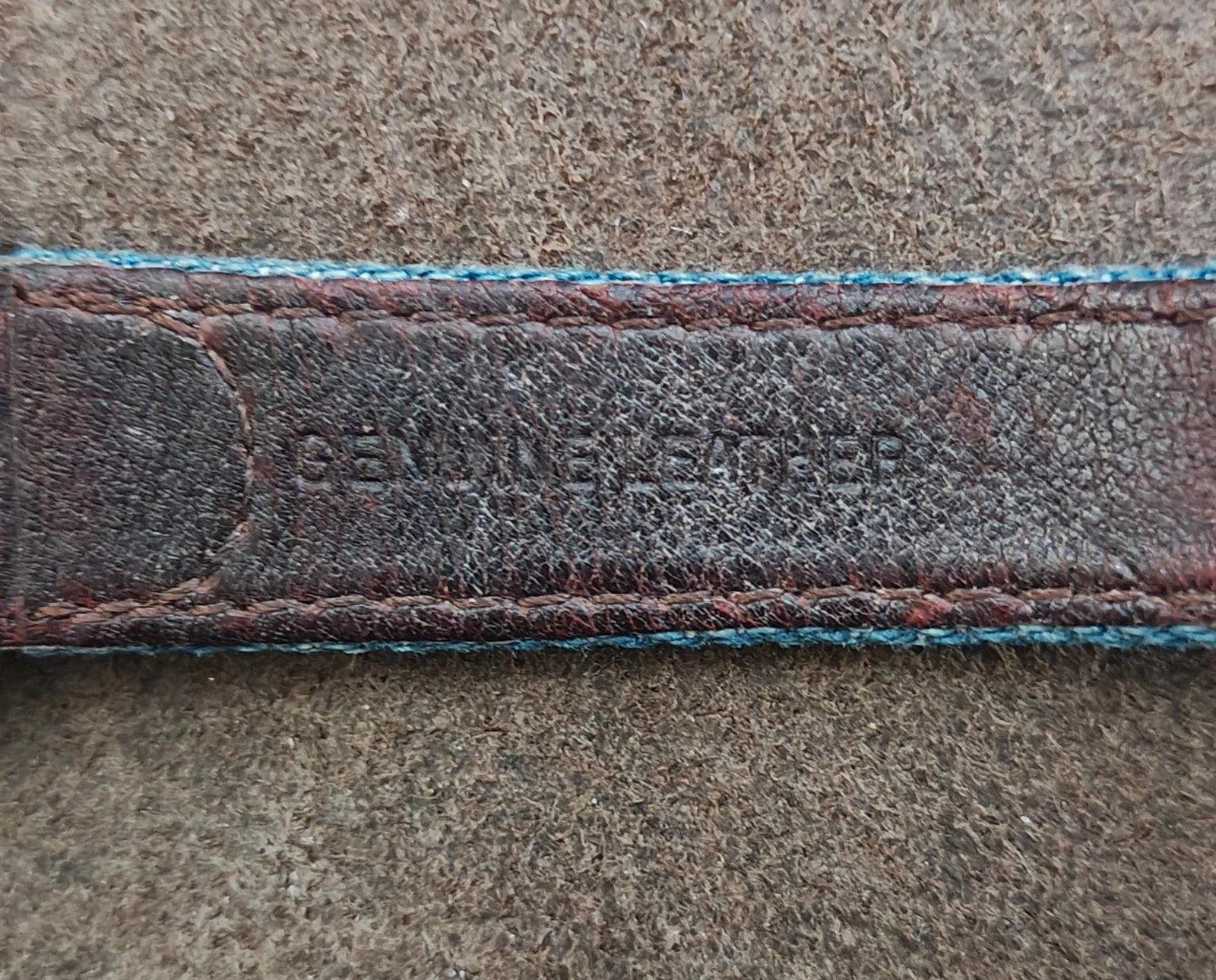 Blue fabric watch strap with dark leather lining and stitched edge