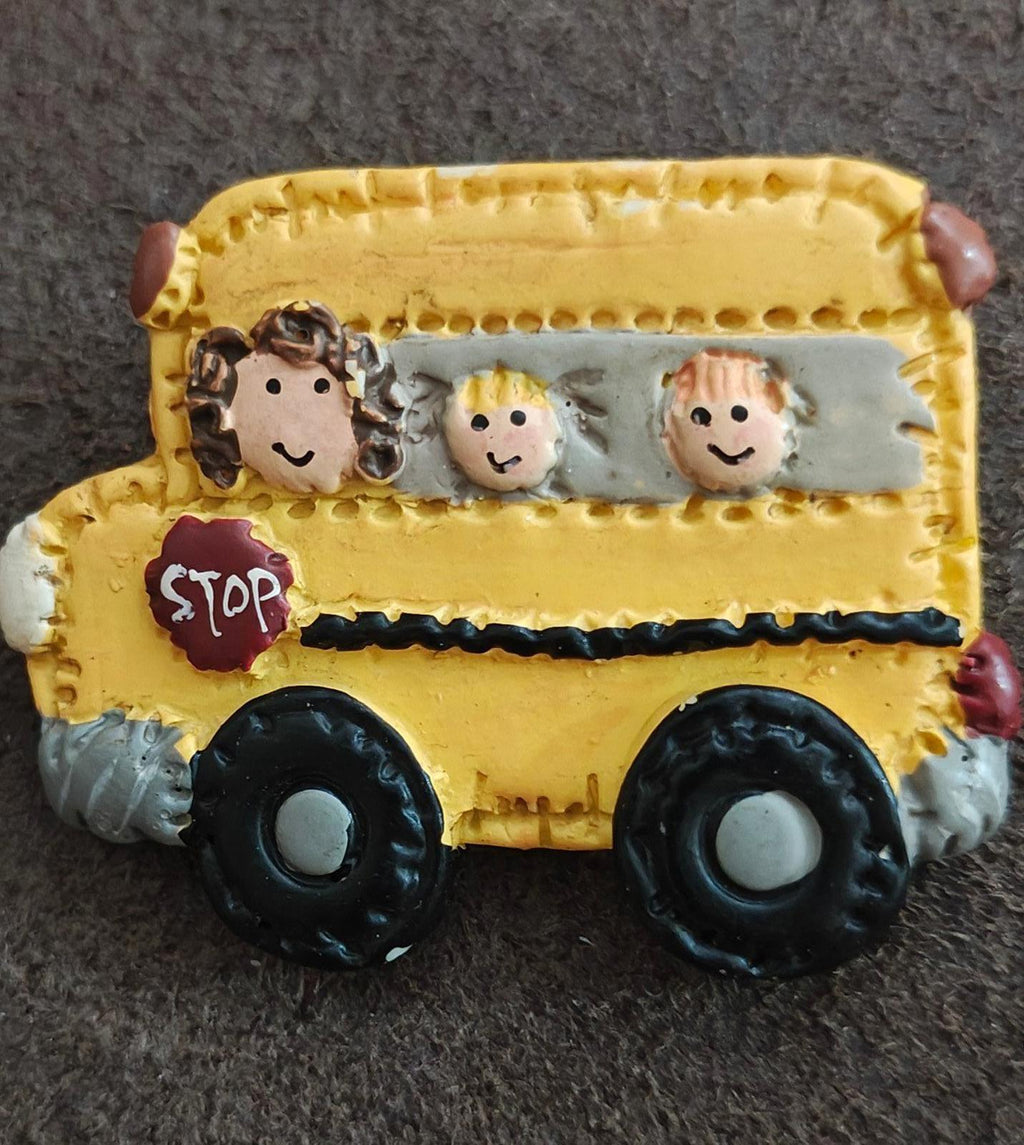 Yellow school bus resin pin close-up with cartoon kids and red STOP sign