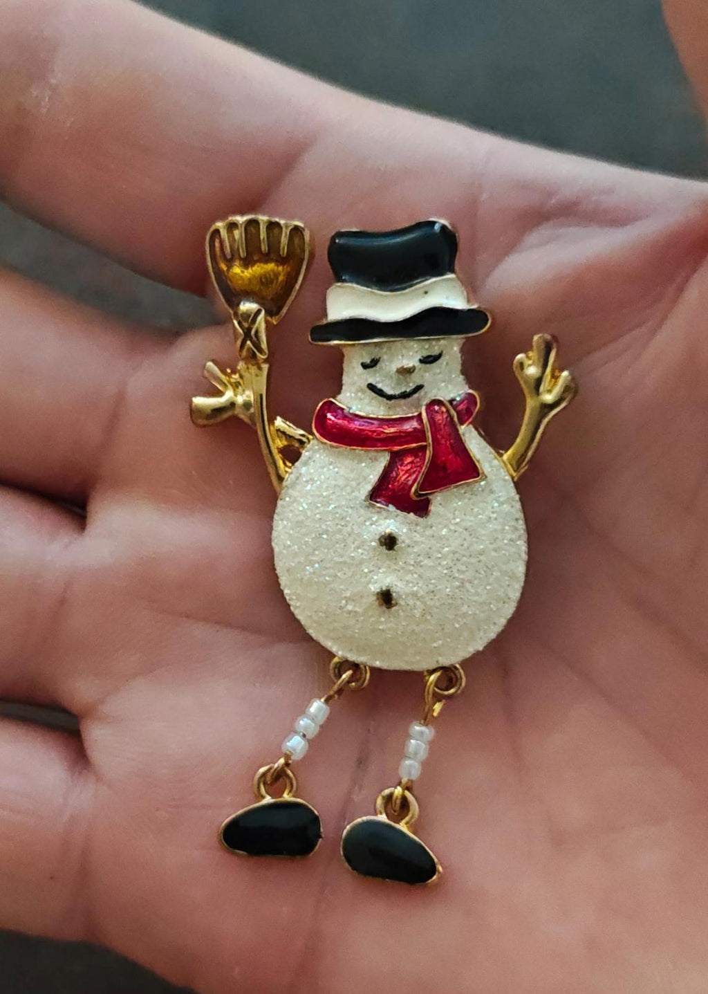 Gold tone snowman enamel brooch with white glitter body, red scarf, black hat and boots.