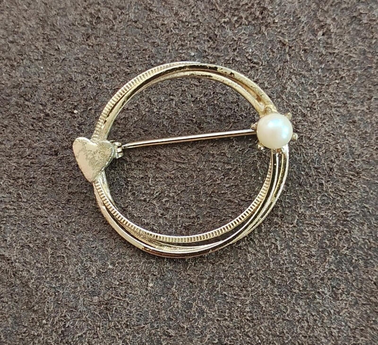 Gold-tone round eternity brooch with textured band and off-white pearl bead