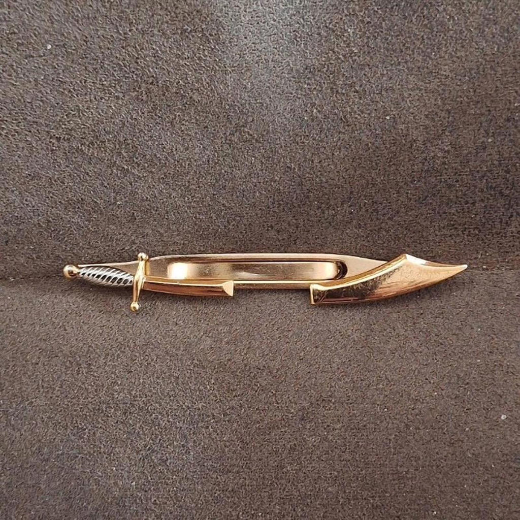 Gold pirate sword tie clip bar angled view, showing pointed blade and ribbed handle