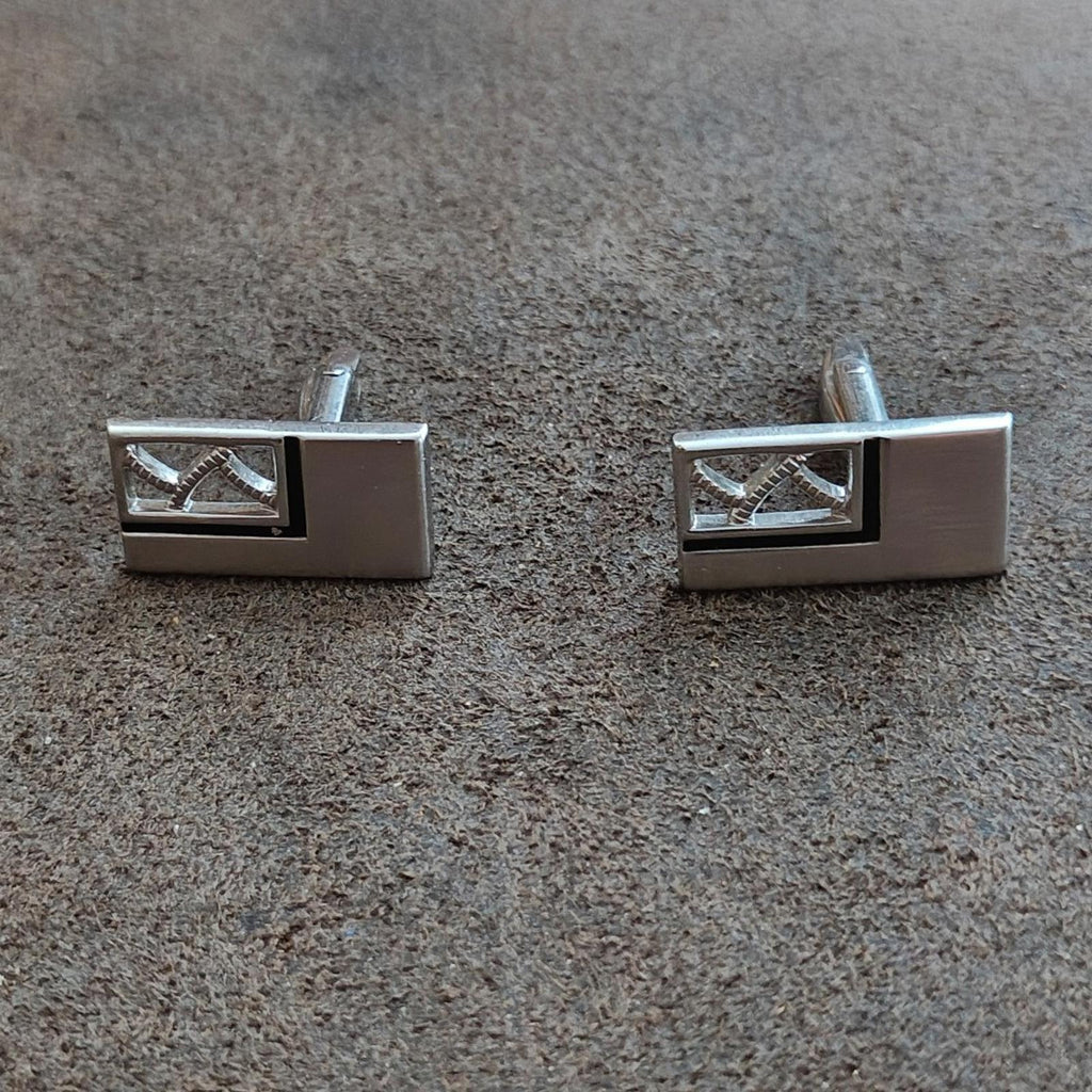 Silver-tone rectangular cufflinks with dark enamel and white geometric inlays