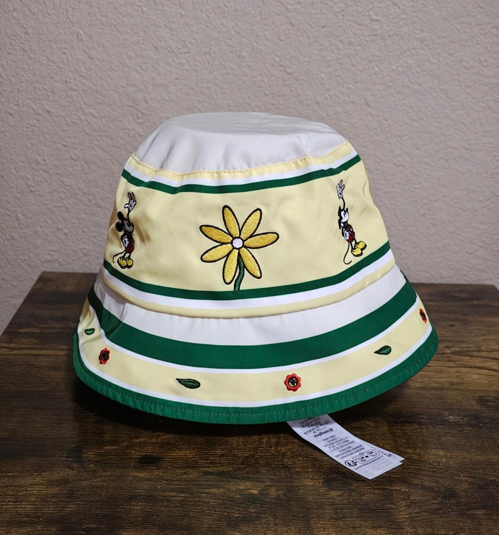 Cream bucket hat with green brim and stripe bands, flower and Mickey Mouse side patches