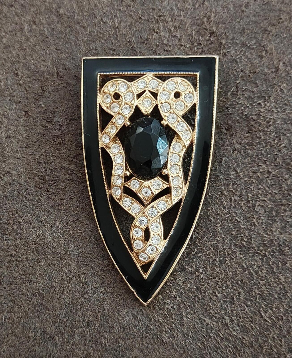 Gold tone Art Deco shield brooch with black oval stone surrounded by clear rhinestone lines