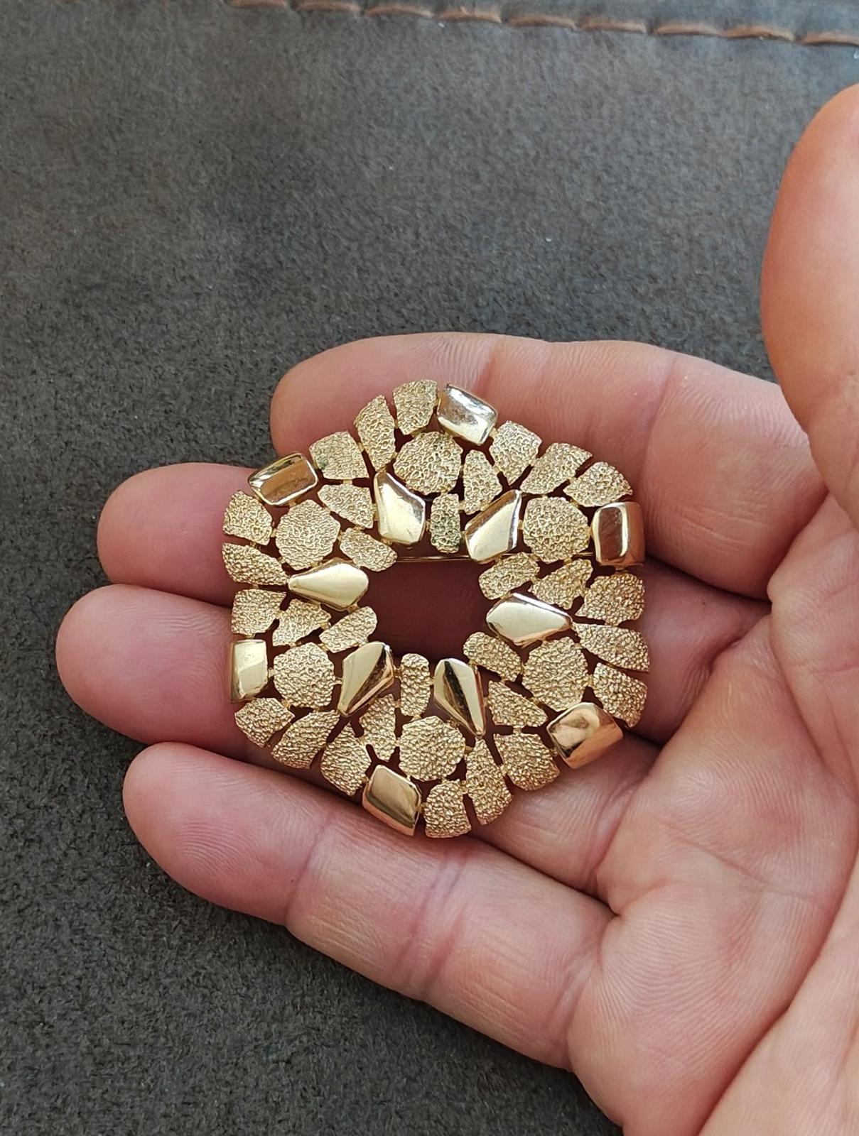 Gold-tone textured wreath brooch with chunky raised pieces and open center