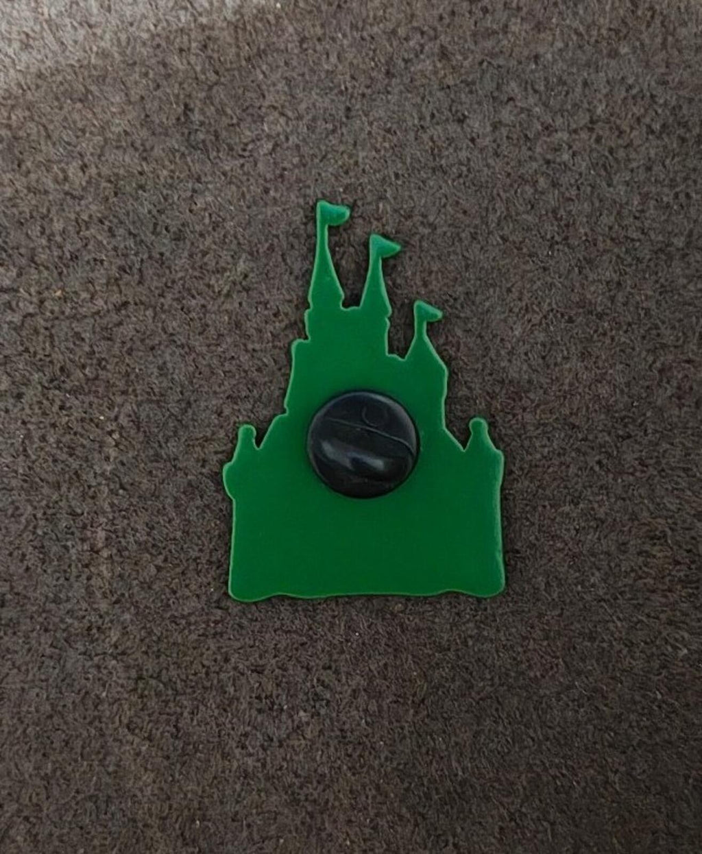 Back of green castle enamel pin with black circular clasp