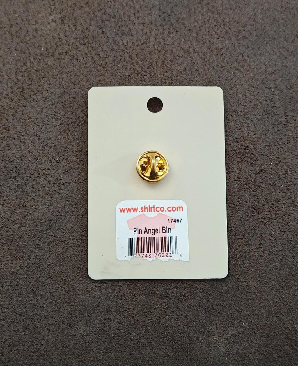 Gold-tone back of enamel pin on card with barcode and website label