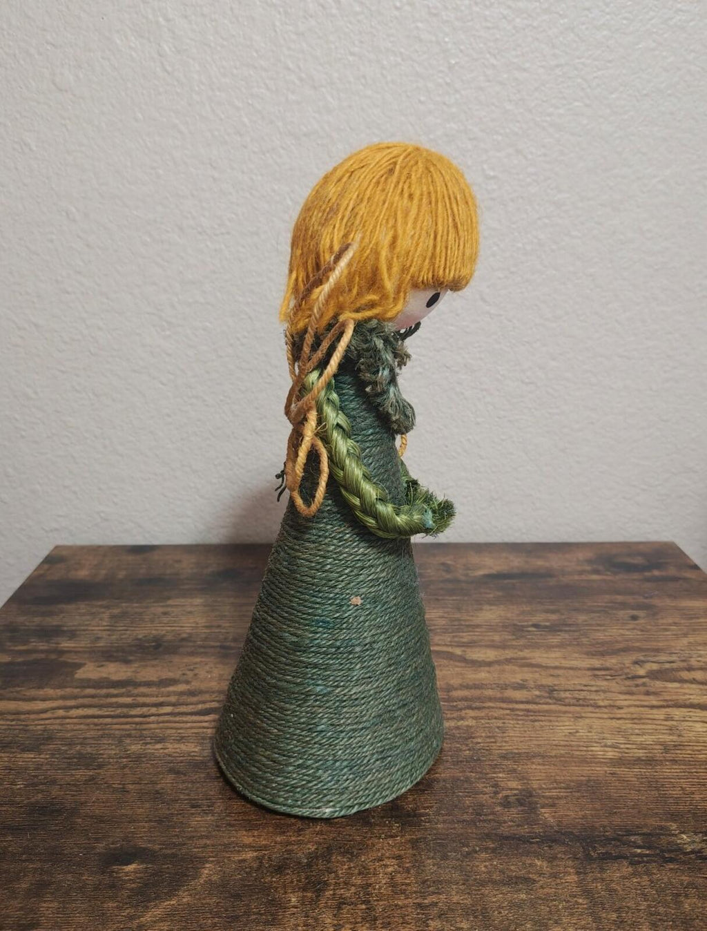 Handcrafted burlap angel tree topper, side profile with dark green dress and blond yarn hair