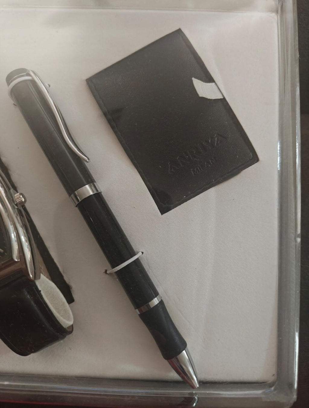 Pen and black cardholder shown with part of the watch inside gift set.