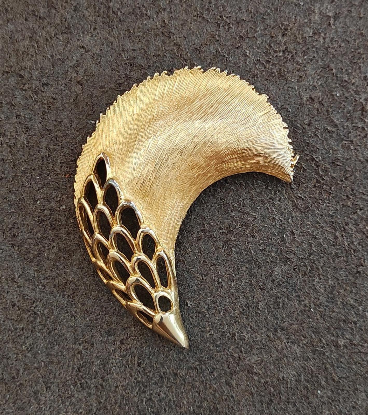 Gold tone feather plume brooch, textured surface with openwork mesh along bottom