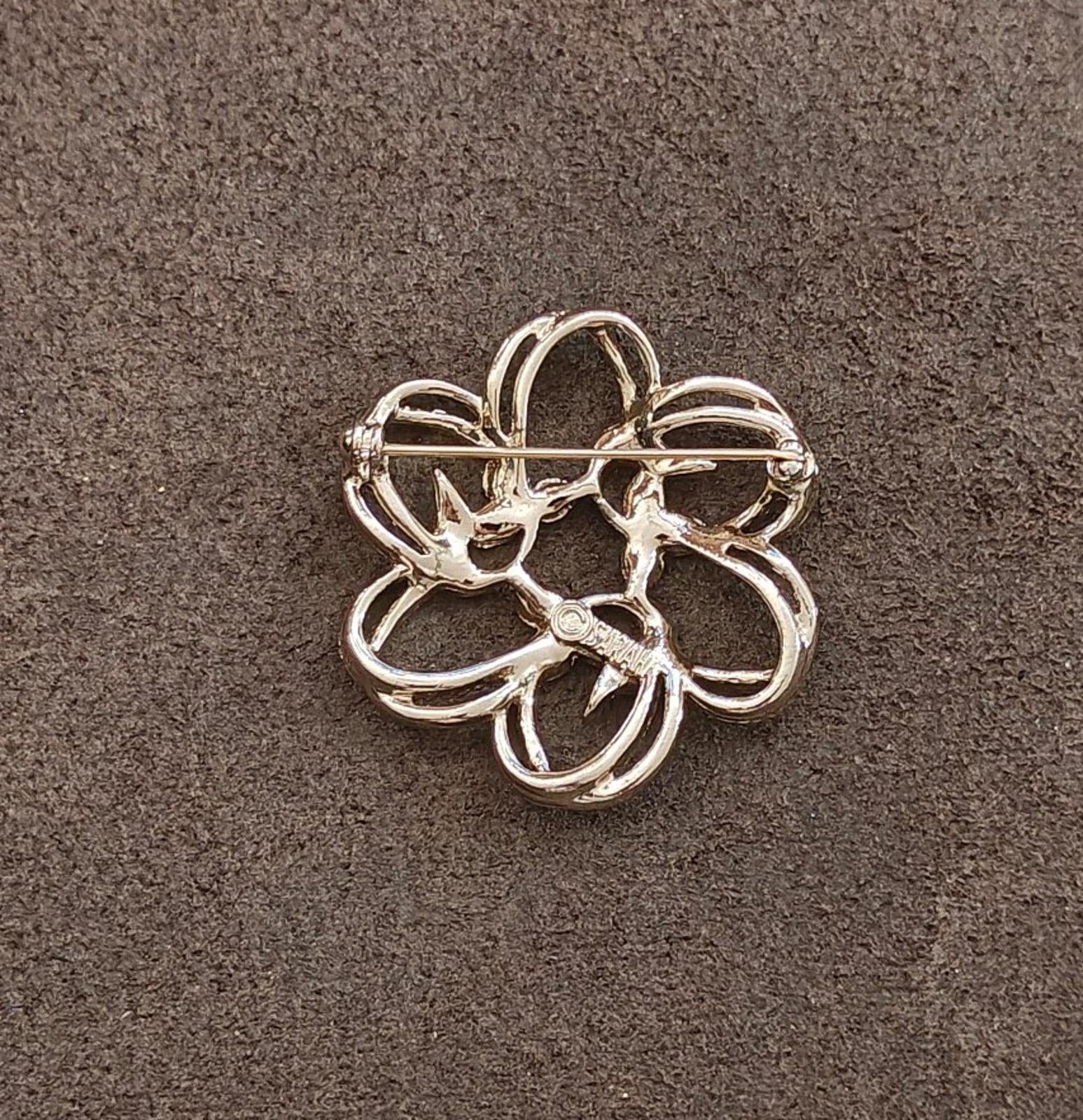 Gold-tone flower brooch with openwork petals and a straight pin bar at back