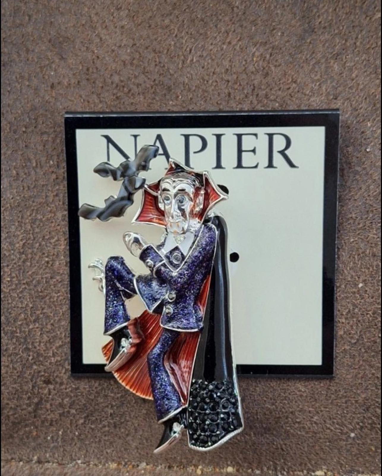 Vampire enamel pin with black cloak, red lining, and blue sparkly torso