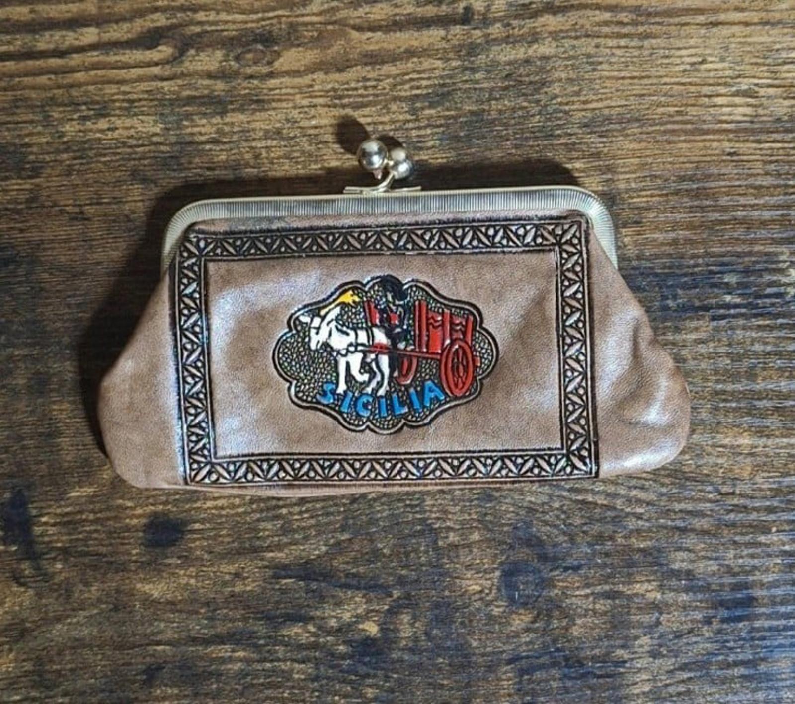 Tan leather coin purse wallet with Sicily crest emblem, metal clasp, and rounded sides.