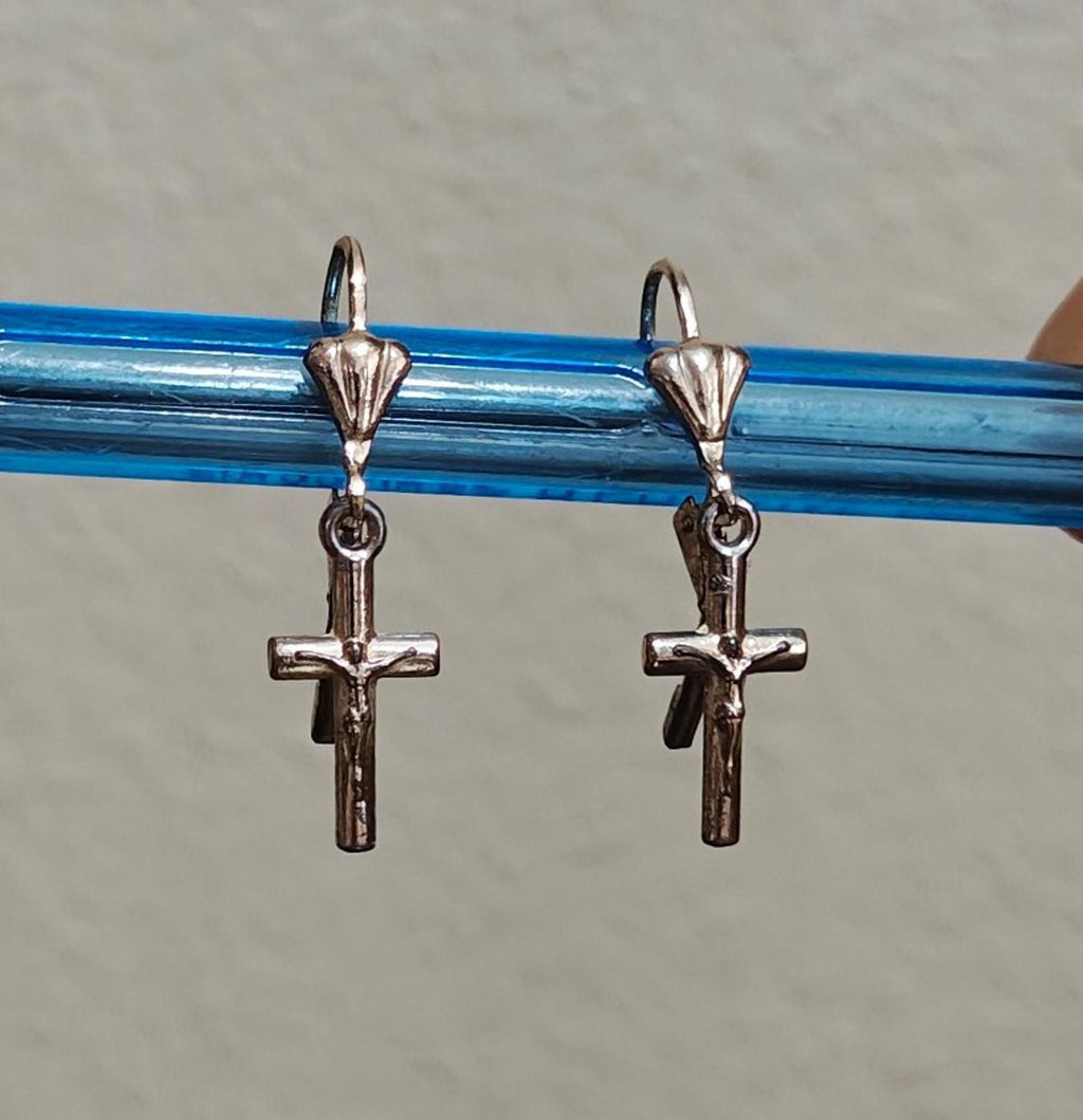 Silver-tone cross dangle earrings with heart tops, shown on a blue bar.