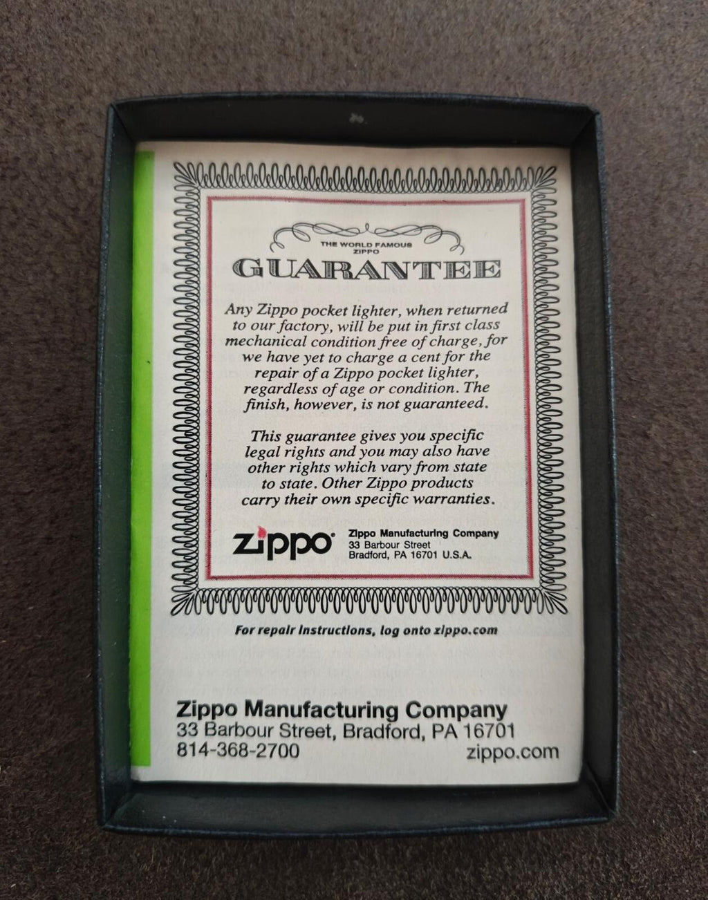 Zippo guarantee card with green border inside black box for silver windproof lighter.