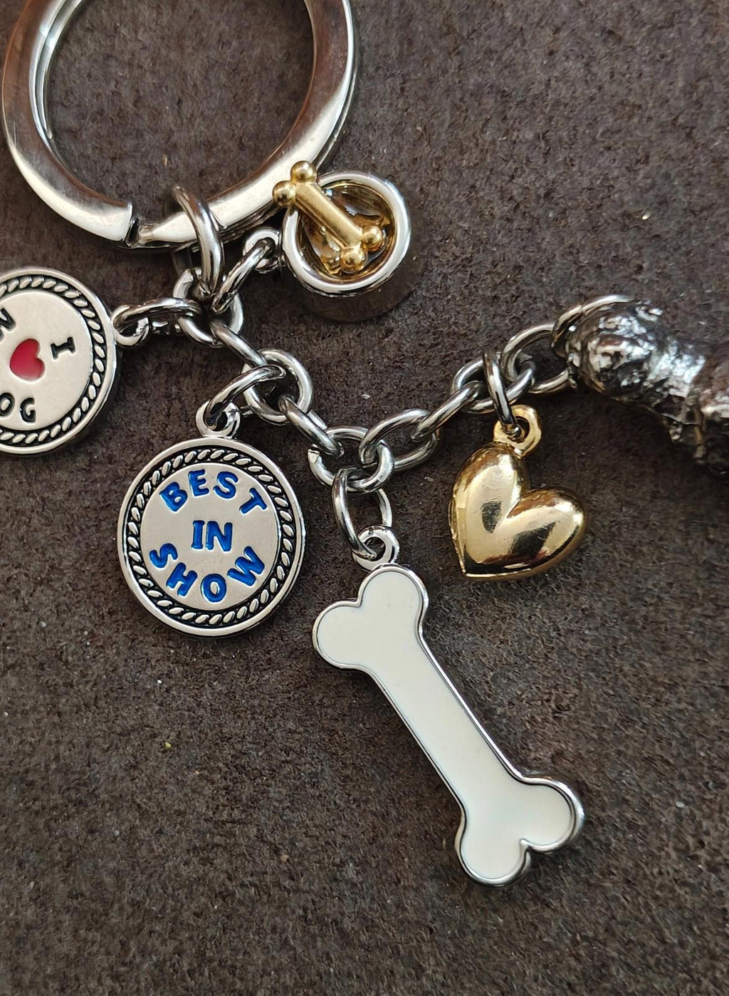 Dog charm keyring with white bone charm, gold heart bell, and round “loves in show” disc