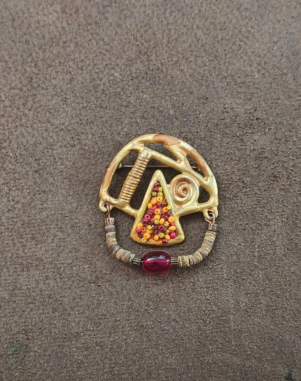 Gold-tone abstract brooch with heishi bead border, multicolor triangle beads, red cabochon