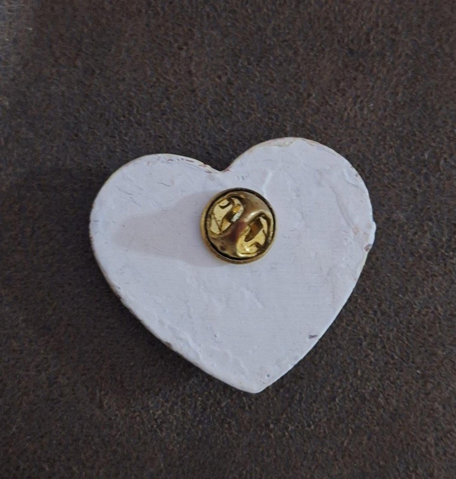 Heart-shaped resin pin with crackled white front and gold-tone metal pin backing