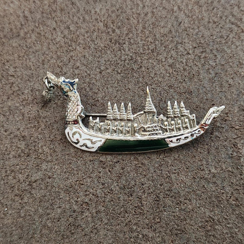 Sterling silver dragon brooch showing detailed temple skyline and dark green enamel base