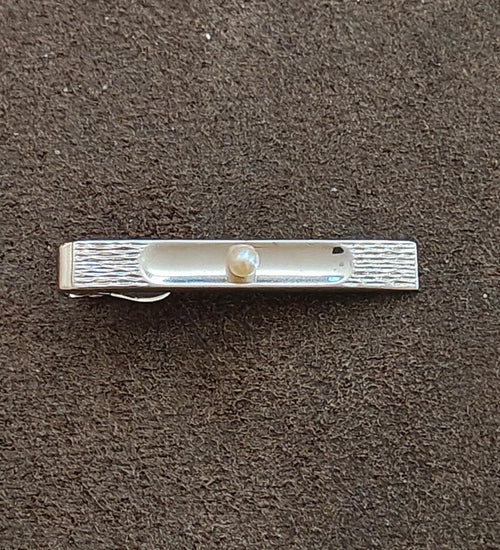 Silver-tone bar pin with centered pearl, rectangular design and textured borders