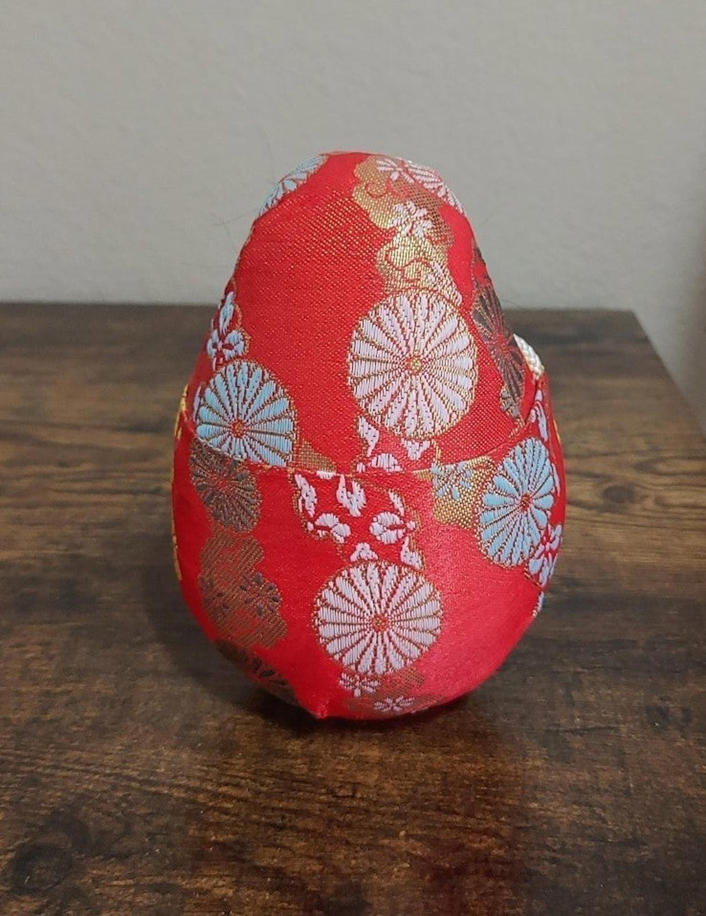 Red Japanese Hime Daruma doll back view with fan and floral embroidery patterns