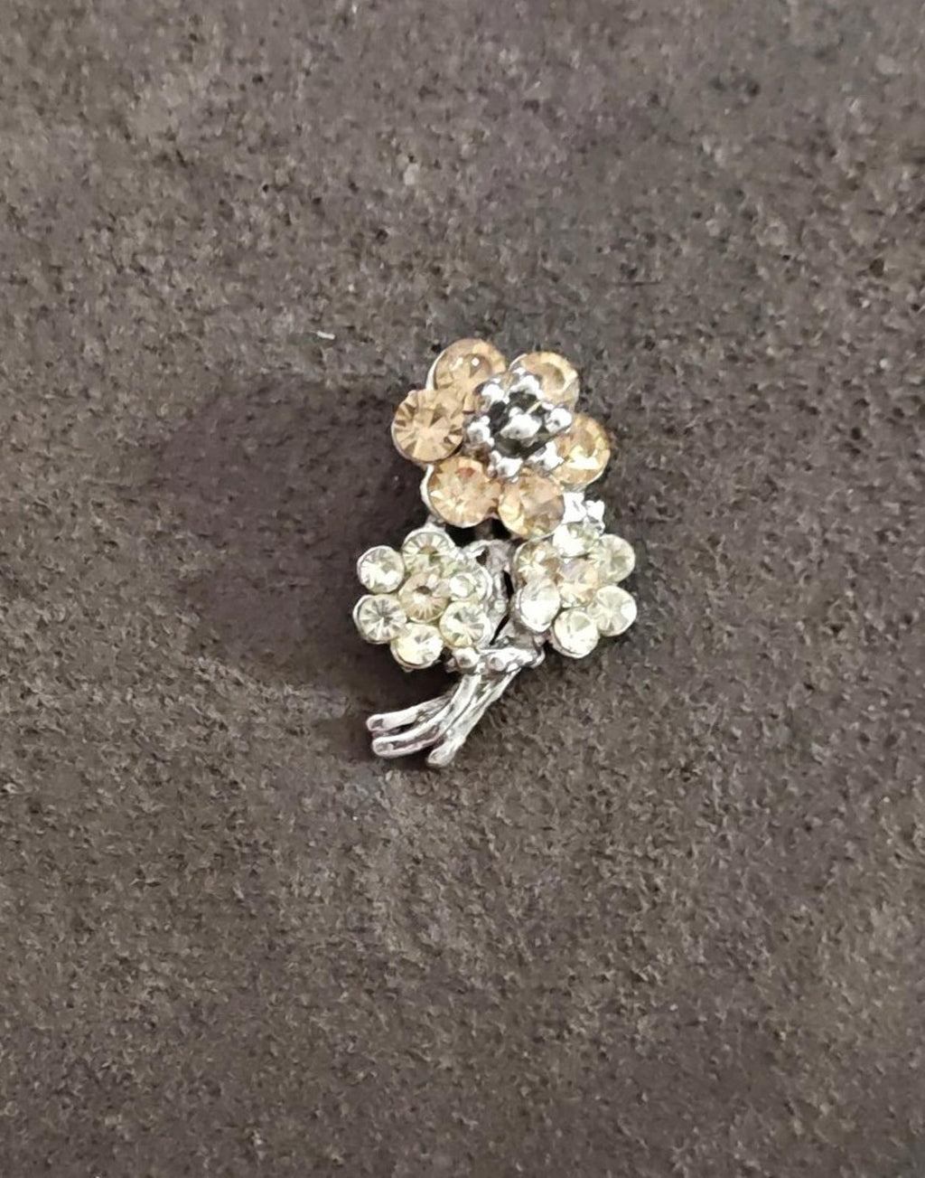 Silver-tone rhinestone flower bouquet brooch viewed from an angle, clustered round stones