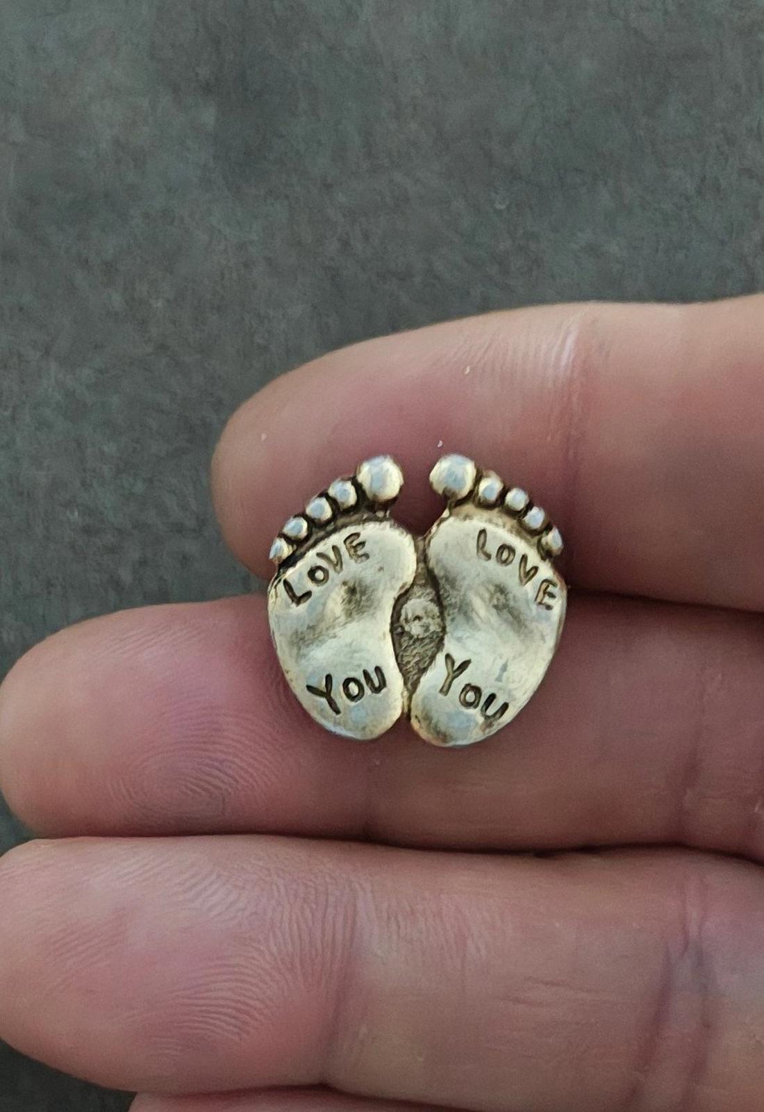 Gold-tone double footprint brooch pin on a finger view, "LOVE" and "YOU" visible