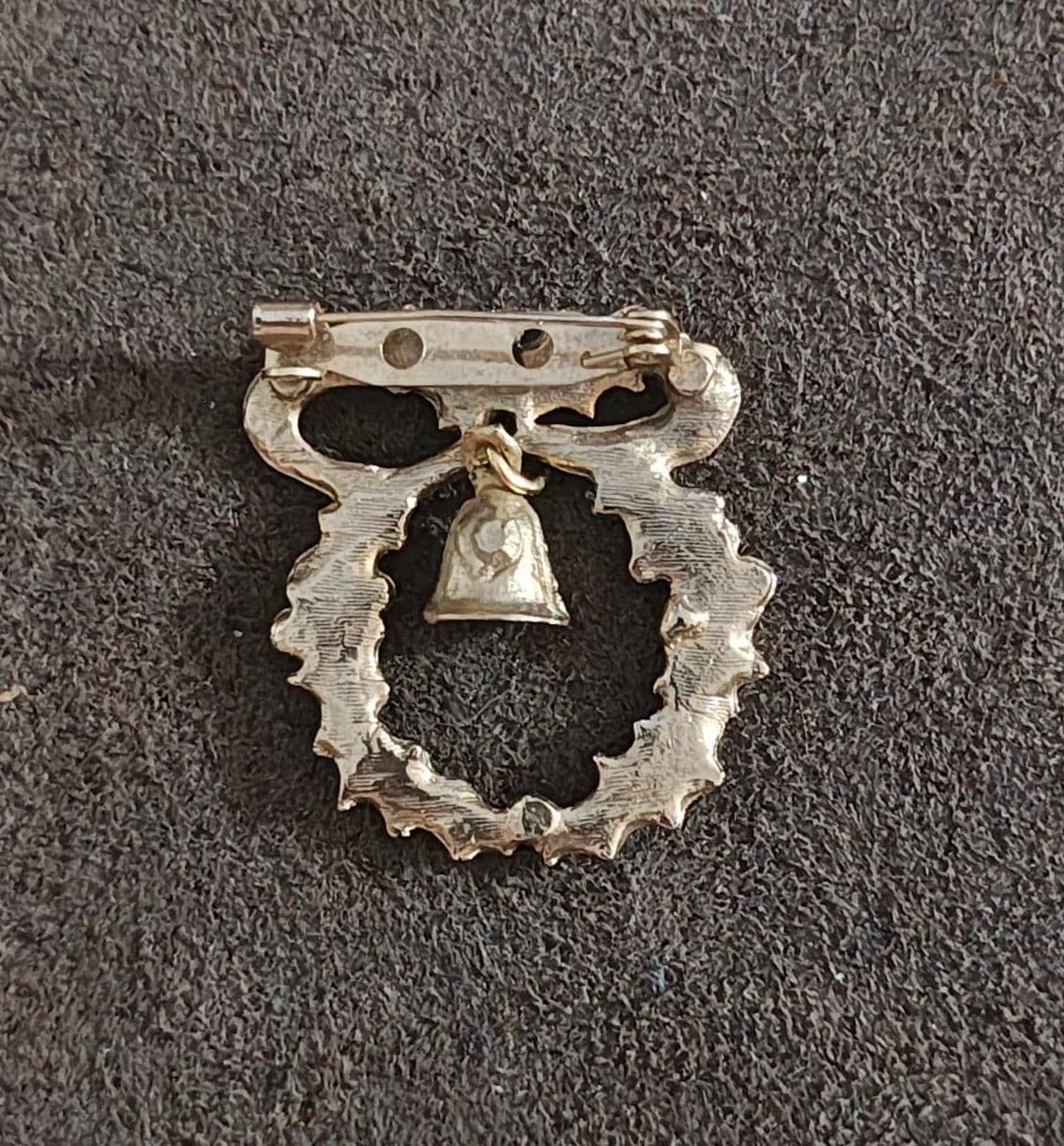 Back of gold-tone Christmas wreath brooch with pin clasp and bar closure