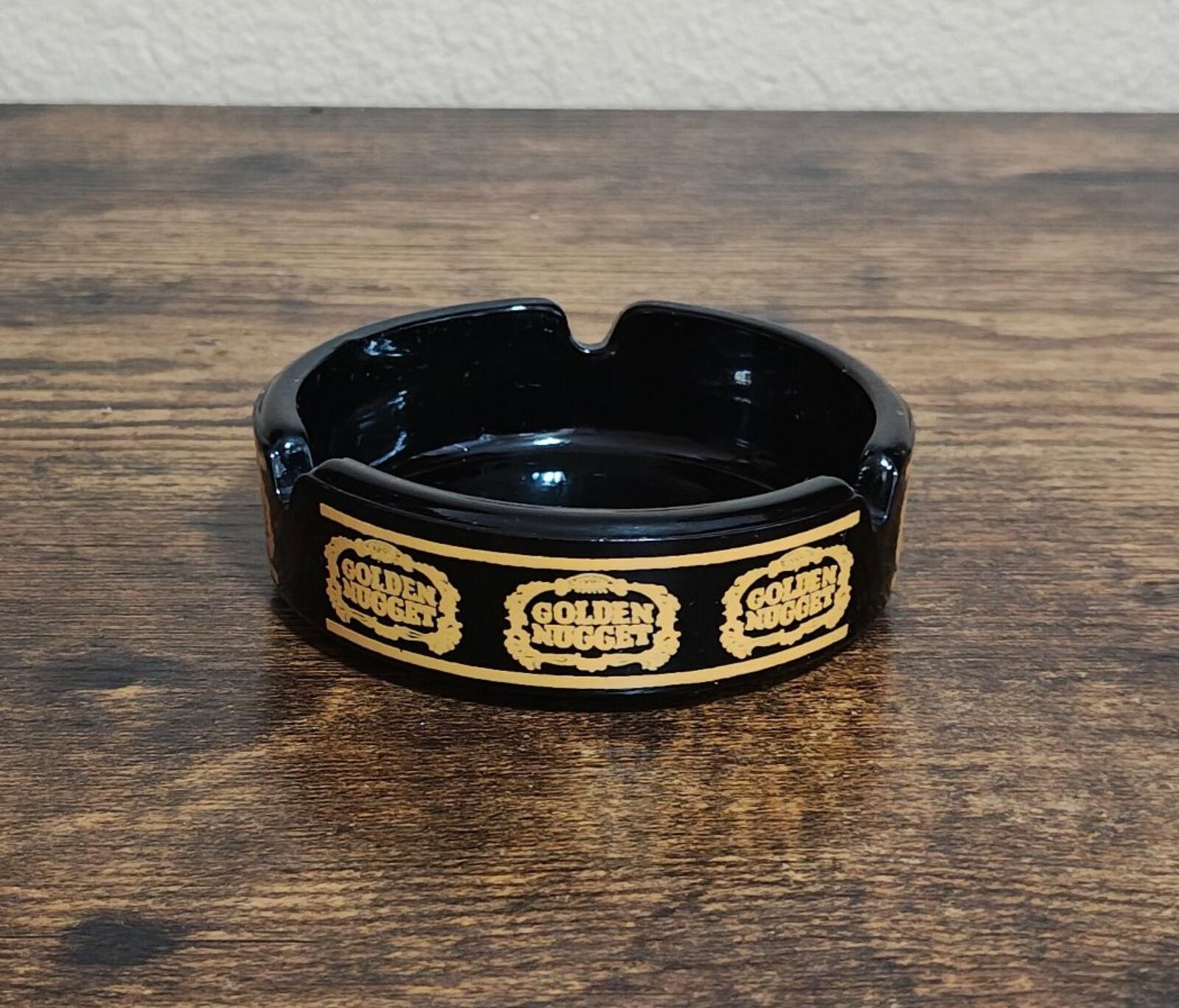 Vintage black ceramic ashtray with open bowl, gold Golden Nugget logo band