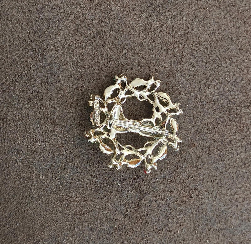 Gold tone back of an enamel holly wreath reindeer brooch, no decorations visible