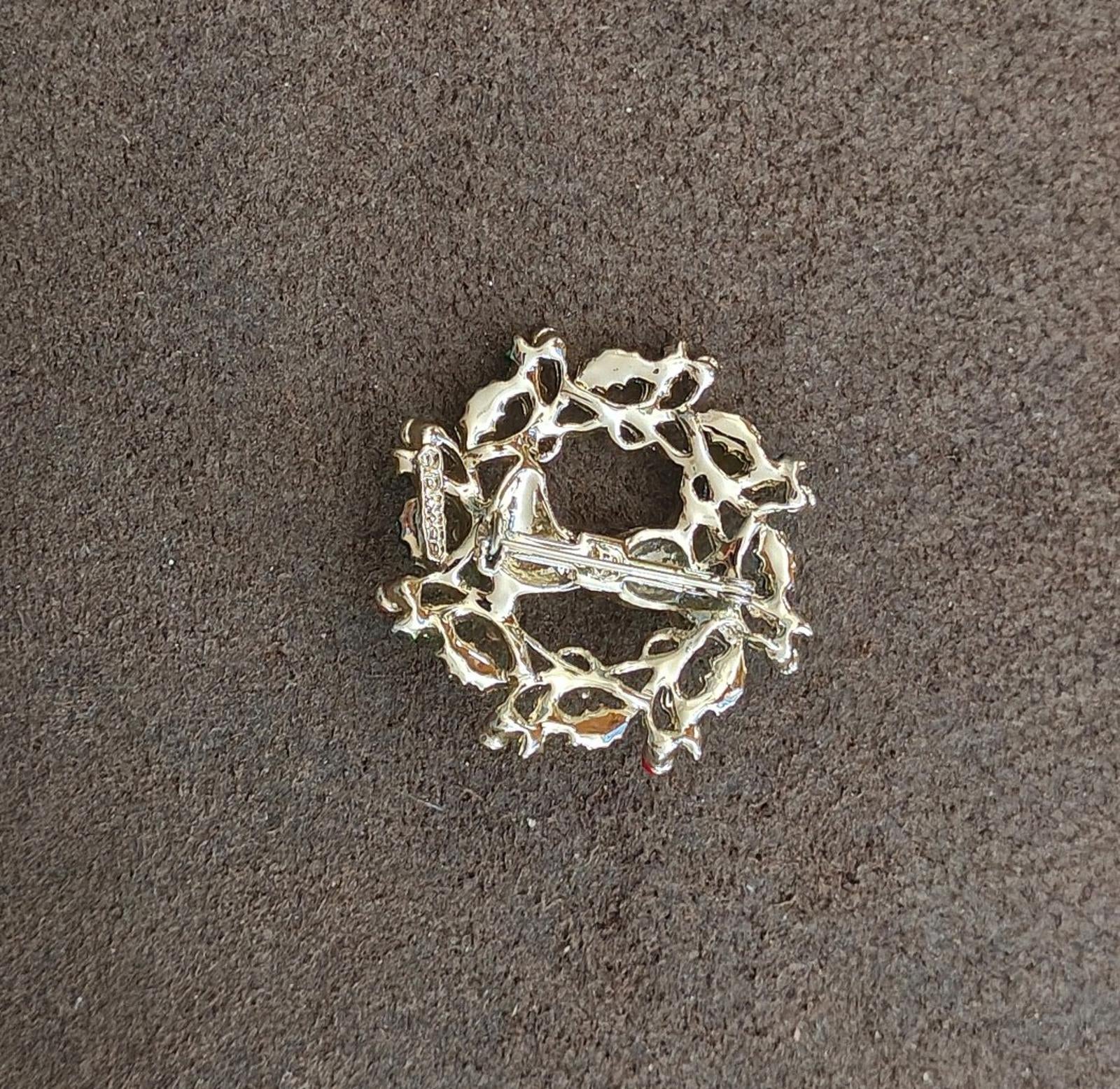 Gold tone back of an enamel holly wreath reindeer brooch, no decorations visible
