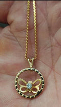 Gold-tone necklace with open circle round pendant, bow-like butterfly detail, clear rhinestone